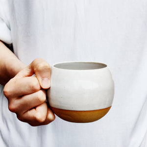 White round cup, tea cup, coffee cup. Unglazed base.